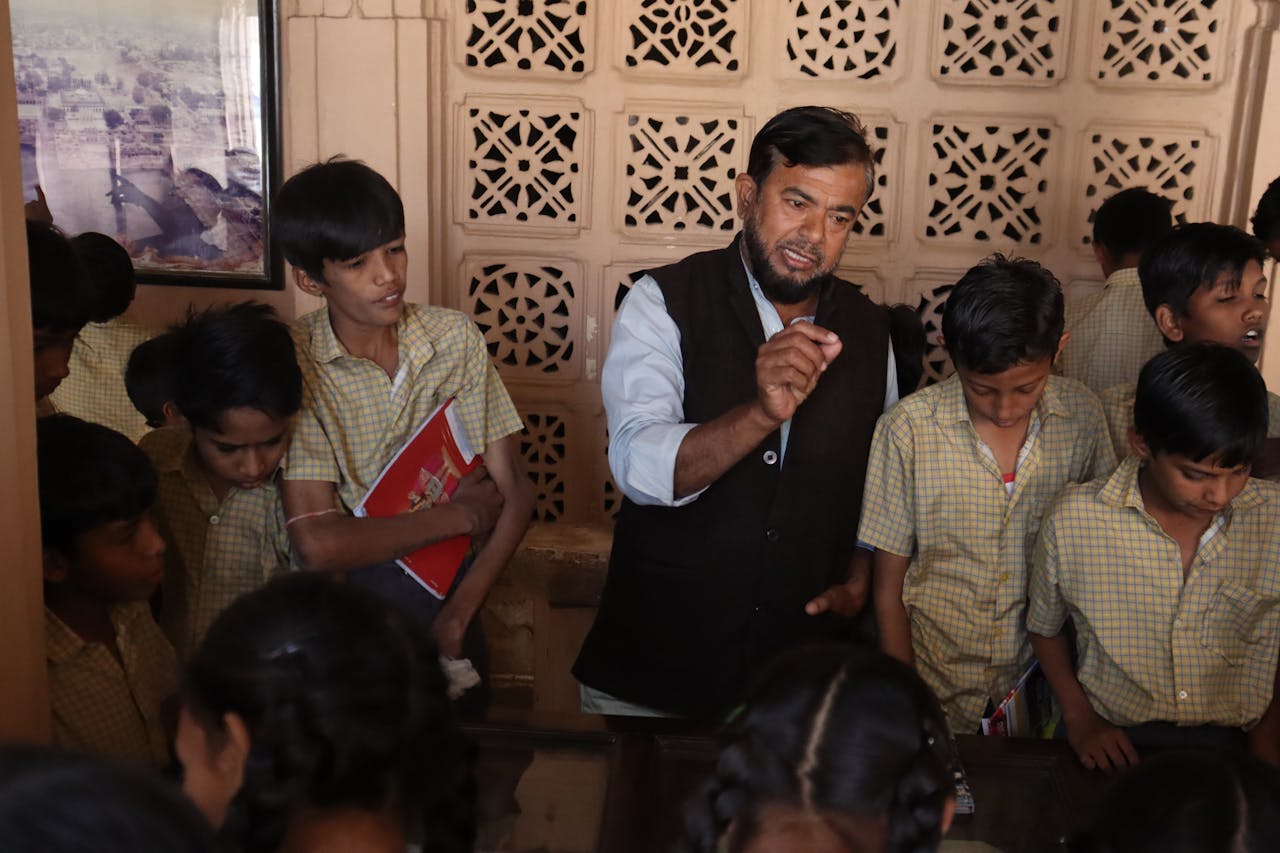 services-03 Teacher guiding attentive students during an interactive indoor lesson, fostering education.